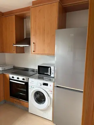 a kitchen with a washing machine and a refrigerator at El rincón de la Mariña in San Cosme de Barreiros