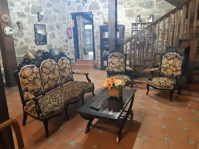 a large room with a stone building with a fireplace at Casa Dulcinea - casa rural en Ribeira Sacra in Serode