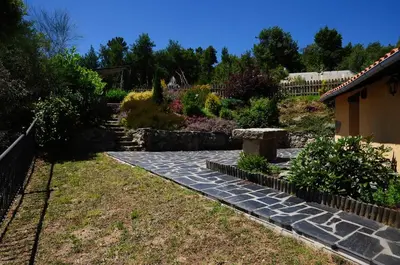 a house with an orange roof and a stone patio at Casa Dulcinea - casa rural en Ribeira Sacra in Serode
