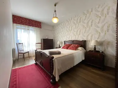 a bedroom with a large bed and a wall with avertisement at Apartamento Cascallar in Caldas de Reis