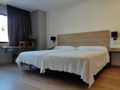 a bedroom with a large bed with a wooden headboard at Hostal los Rosales in Almázcara