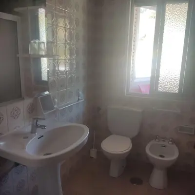 a bathroom with a sink and a toilet and a window at Hostal los Rosales in Almázcara