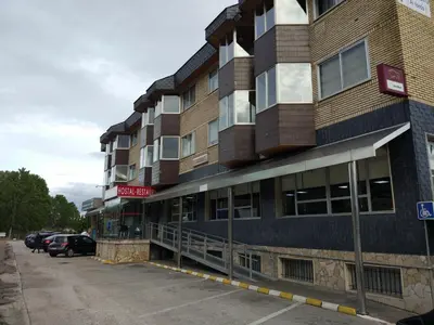 a building with a parking lot in front of it at Hostal los Rosales in Almázcara