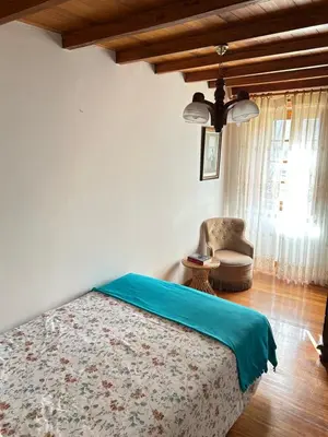 a bedroom with a bed and a chair at Casa Conchas in O Valadouro