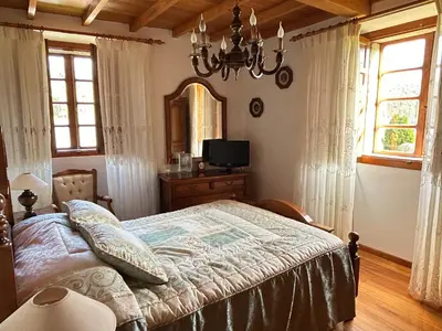 a bedroom with a bed and a mirror and a chandelier at Casa Conchas in O Valadouro