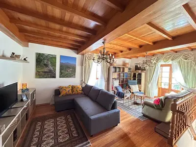 a living room with a couch and a tv at Casa Conchas in O Valadouro