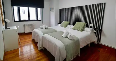 a bedroom with two beds with green pillows at Apartamentos Campus Arzúa in Arzúa