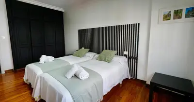 a bedroom with two beds with towels on them at Apartamentos Campus Arzúa in Arzúa
