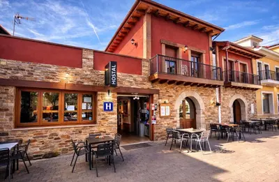a restaurant with tables and chairs in front of a building at hostal Saint James Way in Cacabelos
