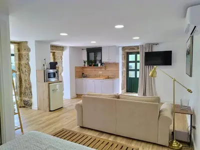 a living room with a couch and a kitchen at Alojamientos as moras arans in La Cañiza