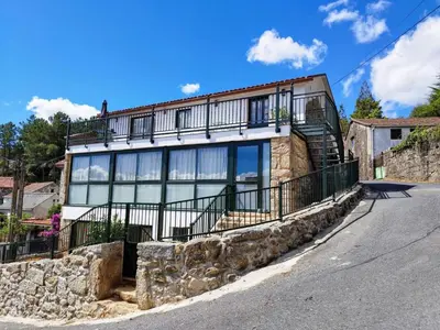 a large house with a balcony on a street at Alojamiento cruceiro Arans in La Cañiza