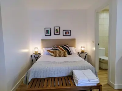 a bedroom with a bed with two lamps and a toilet at Alojamiento cruceiro Arans in La Cañiza