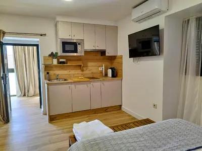 a small kitchen with white cabinets and a microwave at Alojamiento cruceiro Arans in La Cañiza