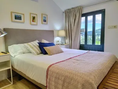 a bedroom with a large bed with a large window at Alojamientos arans in La Cañiza