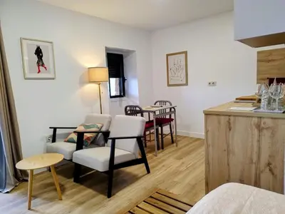 a kitchen and living room with a table and chairs at Alojamiento piñeiro arans in Oroso