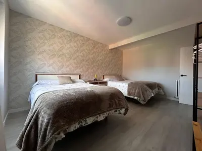 a bedroom with two beds and a refrigerator at VUT La CEPEDA in Astorga