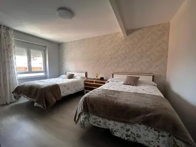 a bedroom with two beds and a window at VUT La CEPEDA in Astorga