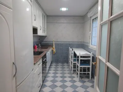 a small kitchen with white cabinets and a checkered floor at Atico centrico Lela Lemos-3 habitaciones y 3 baños in Monforte de Lemos