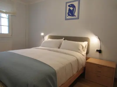 a bedroom with a large bed with white sheets and a lamp at Atico centrico Lela Lemos-3 habitaciones y 3 baños in Monforte de Lemos