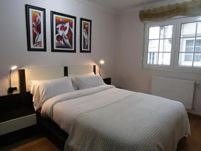 a bedroom with a white bed and two windows at Atico centrico Lela Lemos-3 habitaciones y 3 baños in Monforte de Lemos