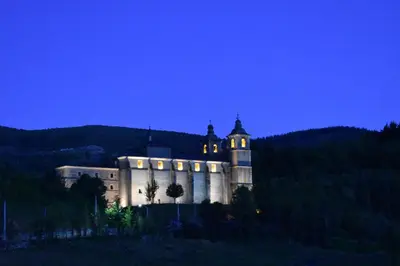 a castle sitting on top of a hill at night at Apartamentos Picea Azul in Vega de Espinareda
