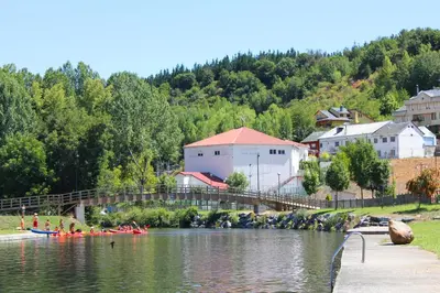 a group of people kayaking on a river with a bridge at Apartamentos Picea Azul in Vega de Espinareda
