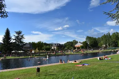 a group of people swimming in a body of water at Apartamentos Picea Azul in Vega de Espinareda