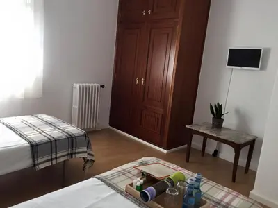 a bedroom with a bed and a table with bottles on the floor at MON ComeySueña Guesthouse in Monforte de Lemos