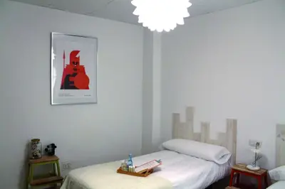 a bedroom with a bed and a picture of a guitar at MON ComeySueña Guesthouse in Monforte de Lemos
