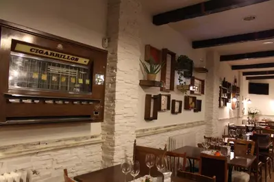 a restaurant with a bar with tables and chairs at MON ComeySueña Guesthouse in Monforte de Lemos