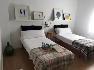 a bedroom with two beds and a table with drinks on it at MON ComeySueña Guesthouse in Monforte de Lemos