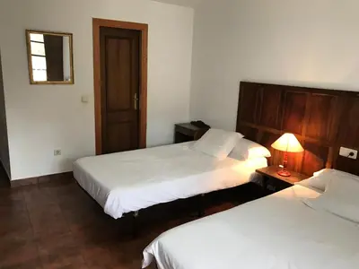 a bedroom with two beds and a lamp on a table at La Casa Del Reloj in Molinaseca