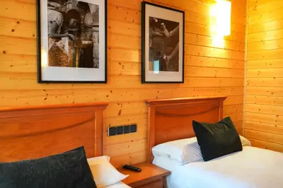 a bedroom with two beds and pictures on the wall at Alda Palas de Rei in Palas de Rei