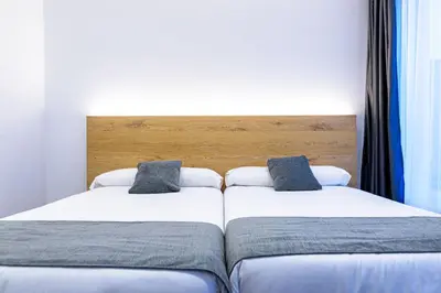 two beds sitting next to each other in a bedroom at Alda Palas de Rei in Palas de Rei