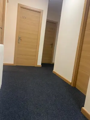 two doors in an empty room with carpet at Pension Valcarce in Ponferrada