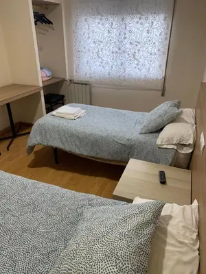 a room with two beds and a window at Pension Valcarce in Ponferrada
