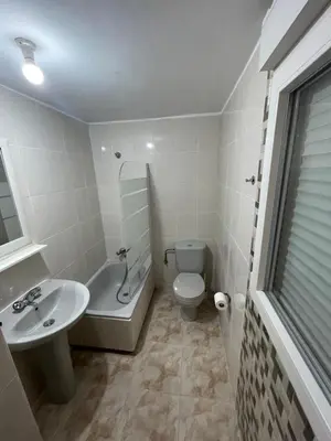 a white bathroom with a sink and a toilet at Pension Valcarce in Ponferrada