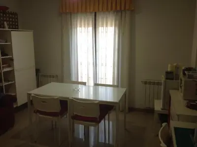 a kitchen with a white table and chairs and a window at Hostal Las Eras in Cubillos del Sil