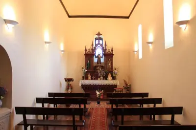 a church with a altar with benches and a clock at Pazo Torre Do Barrio in Loseiro
