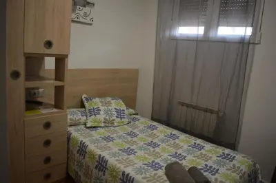 a bedroom with a bed and a dresser and a window at Hospedaje Jose Rey in Santiago de Compostela