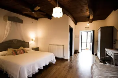 a bedroom with a large white bed and a table at La Casa Grande Del Valle in El Valle