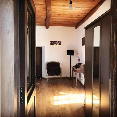 a living room with a wooden ceiling and a chair at La Casa Grande Del Valle in El Valle