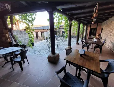 a patio with tables and chairs and a stone wall at La Casa Grande Del Valle in El Valle
