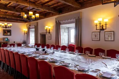 a long table in a room with red chairs at Parador de Monforte de Lemos in Monforte de Lemos