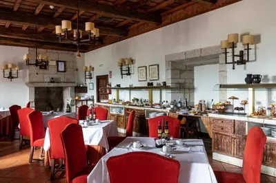 a restaurant with tables and red chairs and a bar at Parador de Monforte de Lemos in Monforte de Lemos