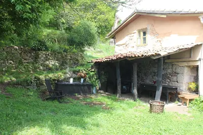 a house with a table and a bench in the yard at Aldea Rural Santo André in Congostro