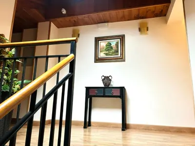 a table next to a staircase with a picture on the wall at Hotel Molina Real in Molinaseca