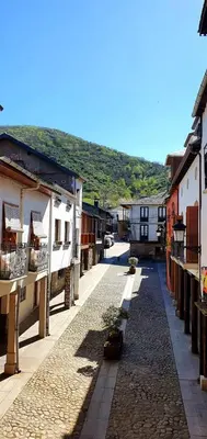 a cobblestone street in a small town with buildings at Hotel Molina Real in Molinaseca