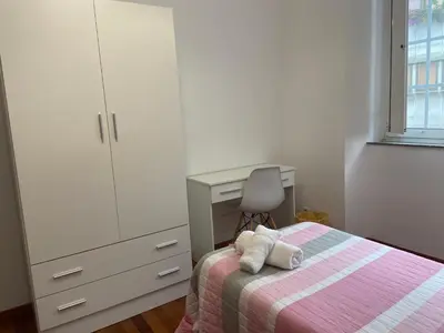 a bedroom with a bed with a dresser and a desk at Pensión Hedrass in Santiago de Compostela