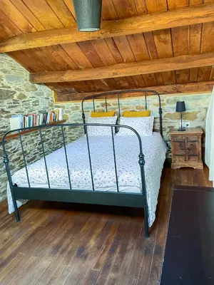 a bed in a room with a wooden ceiling at Galicia Retreat in Santa Marta de Ortigueira